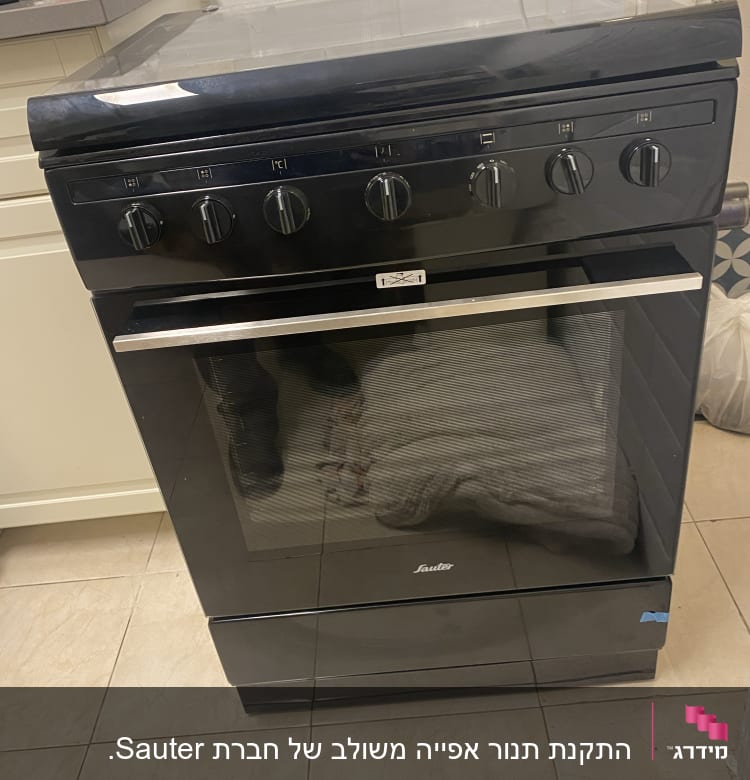 תנור גז שחור עם חמישה כפתורים עליונים